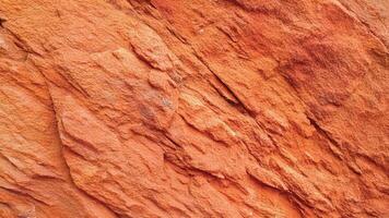 Bright red sedimentary rock with intricate cracks and layered surfaces, highlighting geological formations perfect for architectural designs, nature backgrounds, and artistic patterns. photo