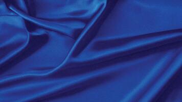 Luxurious royal blue silk fabric background with smooth, flowing folds creating elegant waves and light reflections for fashion, decor, or design projects. photo