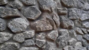 Large uneven stone blocks arranged in a natural, organic pattern for medieval, architectural, or rustic background designs. photo