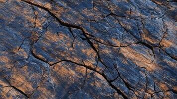 Deep blue slate with contrasting rust cracks, highlighting geological stone formations for abstract backgrounds, interior designs, and architectural surfaces photo