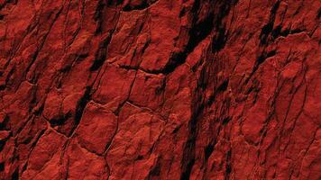 Bright red stone texture with sharp fissures and deep erosion, highlighting natural patterns perfect for design, backgrounds, and architectural inspirations. photo