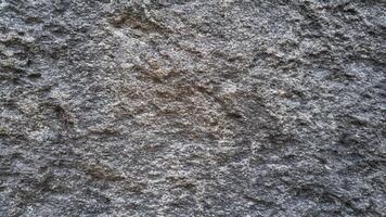 Weathered stone surface with deep textures and natural erosion, great for industrial, architectural, and game design backgrounds. photo