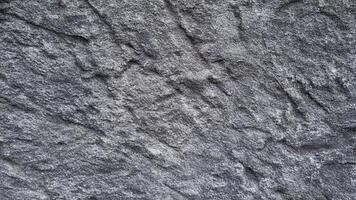 Dark grey stone with deep grooves and textured surfaces, perfect for background use in architectural, industrial, and game design projects. photo