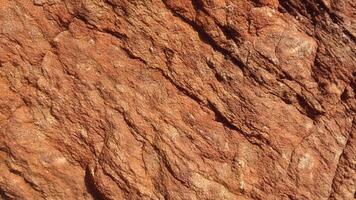 Light brown sedimentary rock with deep cracks and textured layers, showcasing natural erosion perfect for architectural design and background patterns. photo