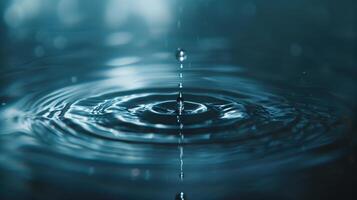 Close-up of water droplet falling into calm surface creating ripples, serene and elegant effect photo