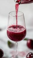 Red wine is poured into a delicate glass. Red juice poured into a glass, refreshing photo