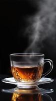 Glass mug of steaming hot tea against a dark background, elegant and warm, with steam rising photo