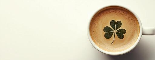 Cup of coffee with a clover leaf design on creamy foam, good luck and St. Patrick's Day photo