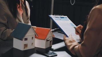 A real estate agent and a client looking at a house video