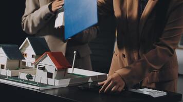 Two people looking at a model of a house video