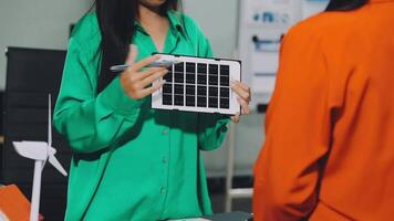 A woman holding a tablet computer with a solar panel on it video