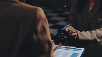 Two people sitting at a table with a clipboard video