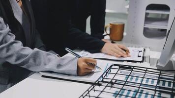 Two people working on a computer with a pen and paper video