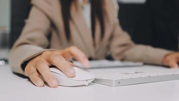 A woman in a business suit is using a computer mouse video
