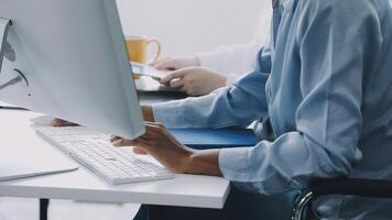 A person sitting at a desk with a computer and a phone video