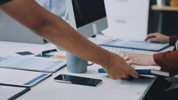 Two people shaking hands at a desk with a laptop video