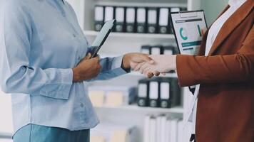 Two business people shaking hands in an office video