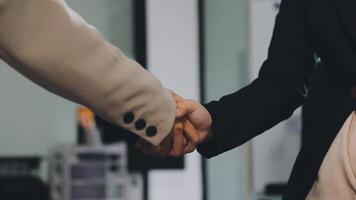 Two business people shaking hands in an office video