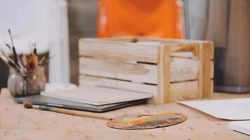 A wooden crate with paint, brushes and a palette on a table video