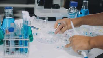 A person is working in a laboratory with blue and white liquid video