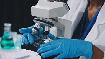 A person in a lab coat is looking at a microscope video