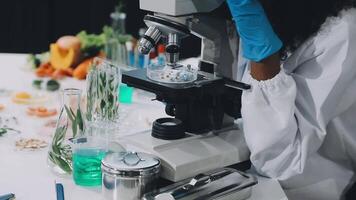 A woman in a lab coat is looking at a microscope video