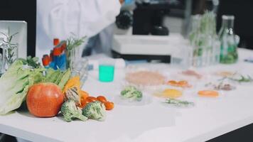 A person in a lab coat is working on a table with various vegetables and fruits video