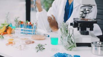 A woman in lab coat is looking at a microscope video