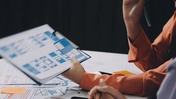 Two people sitting at a table with a laptop and papers video