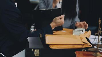 A man and woman are sitting at a desk with a briefcase video