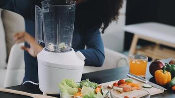 A woman is preparing a smoothie in front of a blender video