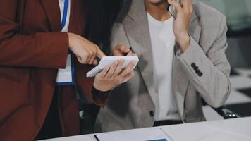 Two business people are looking at a tablet computer video
