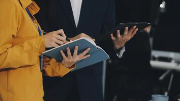 Two people in business attire are holding a tablet video