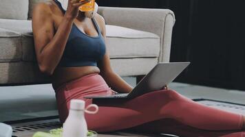 A woman sitting on the floor with a laptop and orange juice video