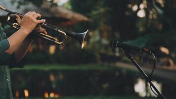 A man is playing a trumpet in front of a microphone video