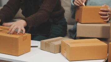 Two people are opening boxes on a table video