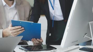 Two people are working on a computer with a clipboard video