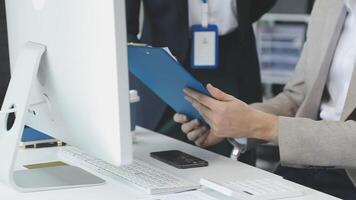 A man in a suit holding a clipboard while sitting at a desk video