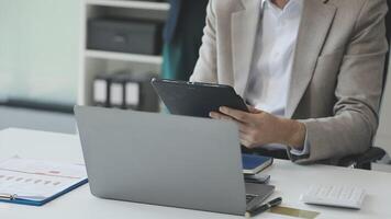 A man in a suit is using a tablet computer video