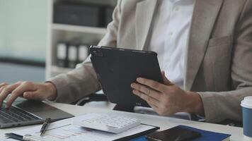 A man in a suit is using a tablet computer video