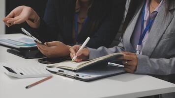 Two business people sitting at a table with a notebook and pen video