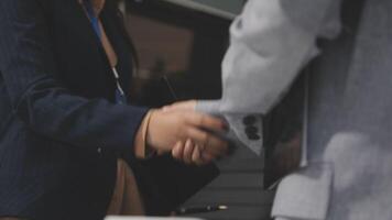 Two business people shaking hands in front of a building video
