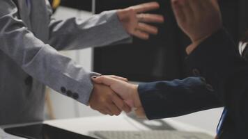 Two business people shaking hands in an office video