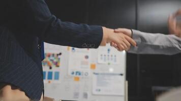 Two business people shaking hands in an office video