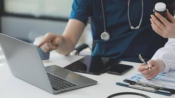 A doctor and a patient are working on a laptop video