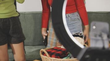 Two women standing in front of a camera and a basket video