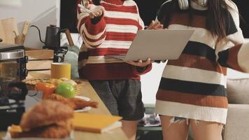 Two women standing in front of a laptop computer video