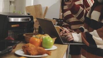 A woman using a laptop while standing in front of a microwave video