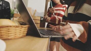 Two women are working on a laptop in the kitchen video