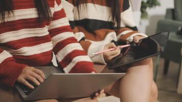 Two women sitting on a couch with laptops video